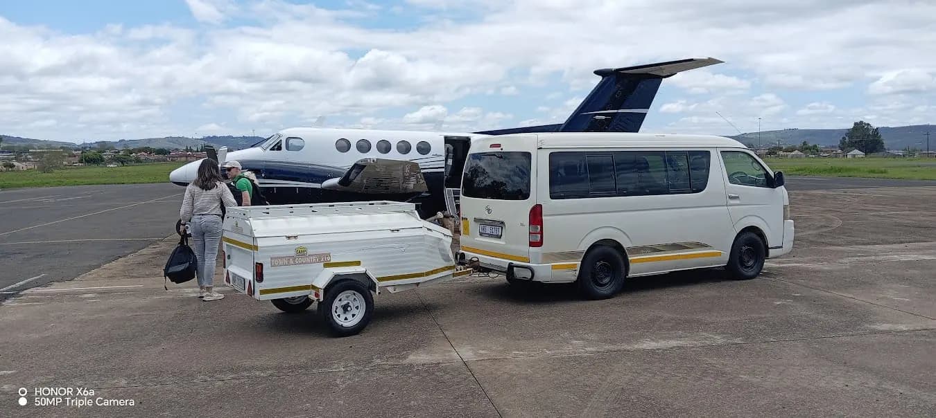 Khondlo Tours minibus with luggage trailer meeting a light aircraft on an airstrip