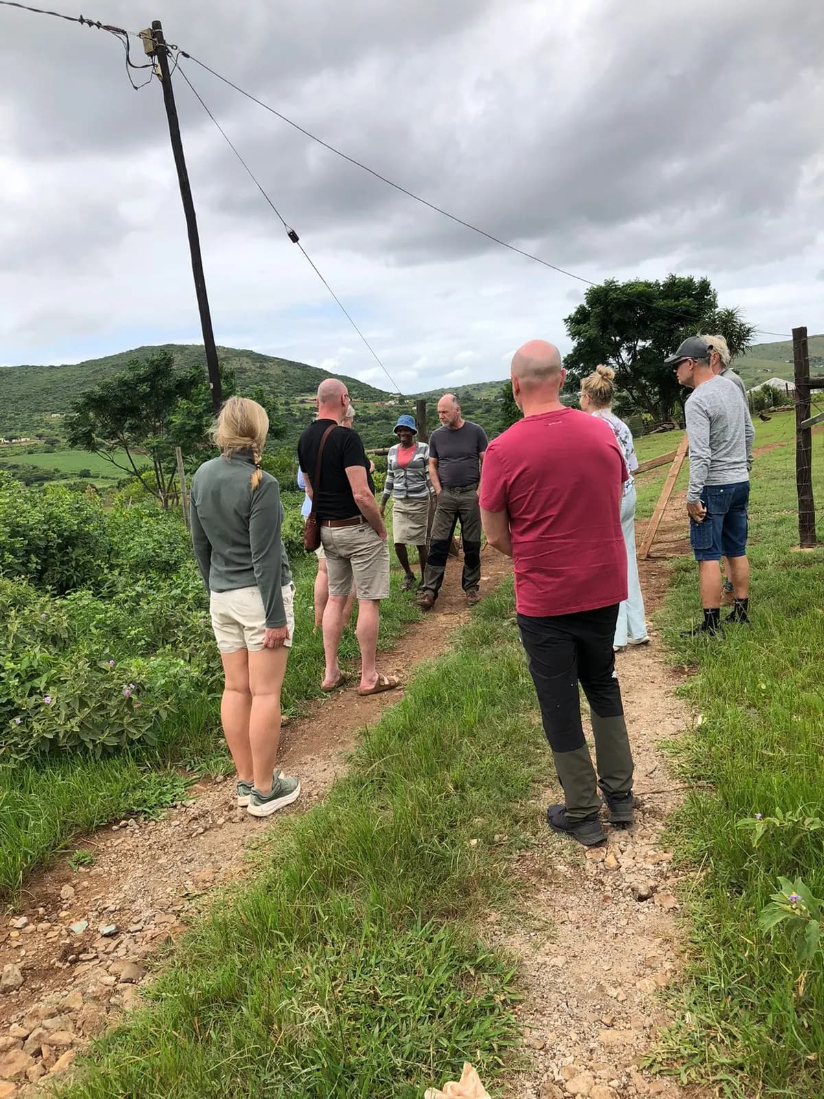 Tour group walking single file on a village path